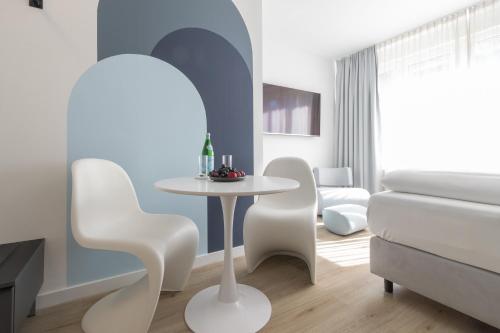 比勒费尔德zzzpace Smart-Hotel Bielefeld Zentrum的客厅配有白色的桌子和椅子