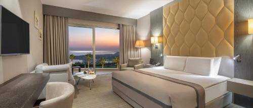 凯里尼亚Elexus Hotel Resort & Spa & Casino的酒店客房设有一张床和一个大窗户