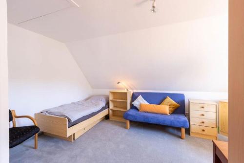 汉诺威Perle am Maschsee. Ein Haus mit Garten und 4 Zimmern的一间卧室配有一张床和一张蓝色椅子