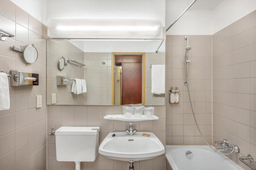 布达佩斯Danubius Hotel Hungaria City Center的一间带水槽、卫生间和镜子的浴室