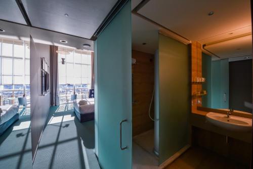 都灵都灵灵格托希尔顿逸林酒店的带淋浴和盥洗盆的浴室