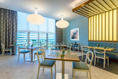 丹吉尔丹吉尔市中心希尔顿花园酒店的餐厅设有桌椅和窗户。