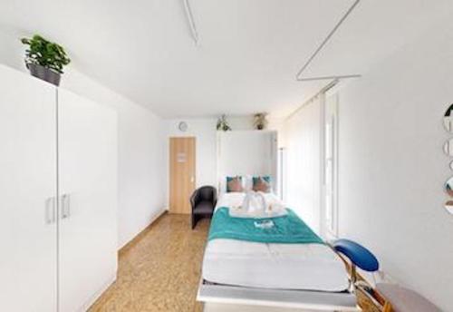 库尔Über den Dächer von Chur (Montalin)的白色的客房配有一张床和椅子