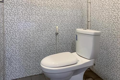 丹戎槟榔RedDoorz Syariah @ Jl D I Panjaitan Batu 7 Tanjung Pinang的浴室铺有黑白瓷砖,设有白色卫生间。