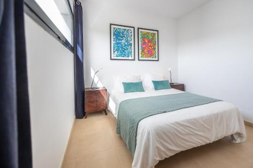 特吉塞Villa LanzaCosta Golf的一间卧室配有白色床和蓝色枕头