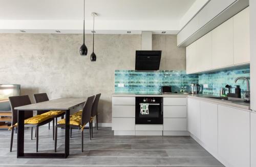 华沙Ochota City View Modern Apartment的厨房配有桌椅和炉灶。