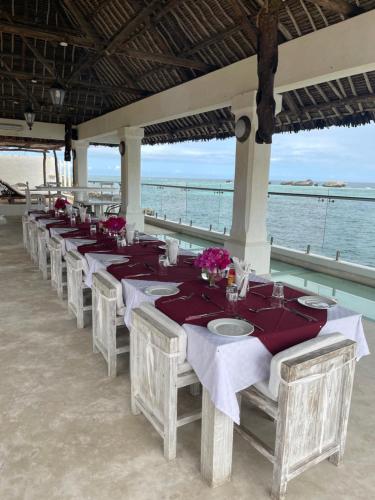 瓦塔穆Mawe Zuri Resort的海滩上一排桌子上放着鲜花