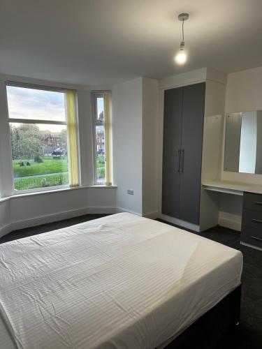 曼彻斯特OYO Cheetham Hill Guest House的卧室设有一张白色大床和两个窗户。