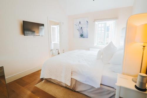 Newbold on Stour法兹达克酒店的白色的卧室设有白色的床和窗户。
