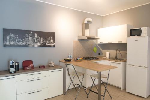 瓦雷泽Cimoneight的厨房配有白色橱柜和木桌