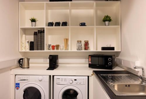 都柏林REZz Dublin的厨房配有洗衣机、烘干机和水槽
