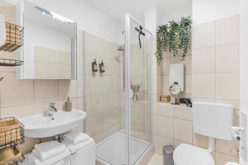 慕尼黑PRIME - City Apartment für 6 - Neu & Modern的带淋浴、卫生间和盥洗盆的浴室