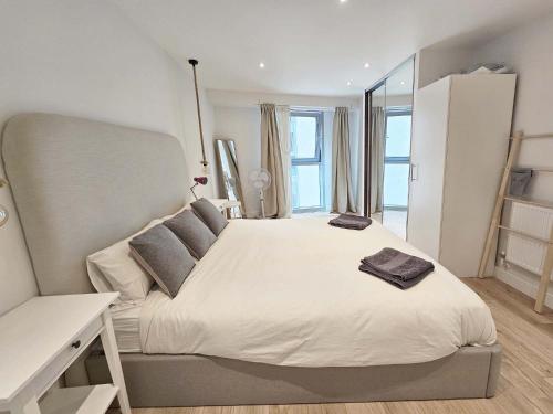 伦敦Beautiful 2 bedroom flat in Battersea的卧室配有一张大白色床和窗户