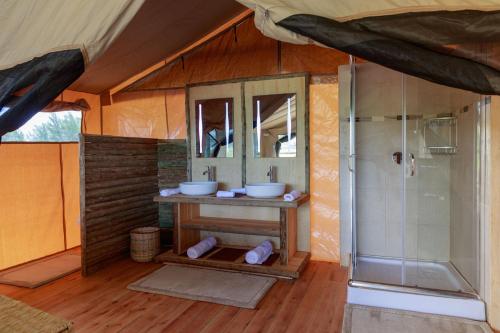 Naro MoruGlamping Kenya Mt. Kenya Lodge的帐篷内的浴室设有2个水槽和淋浴。