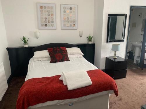 哈特尔普尔三一旅馆的一间卧室配有一张带红白毯子的床