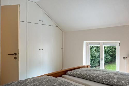 SandstedtFerienwohnung Flut的一间卧室设有两张床和窗户。