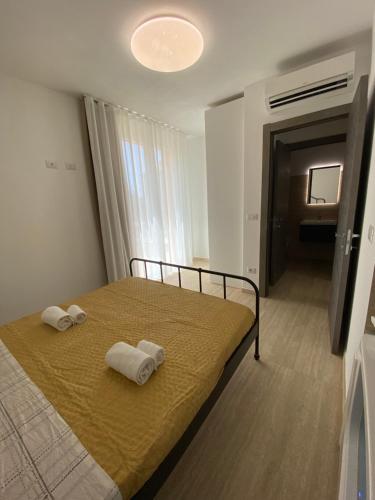 阿尔盖罗Maris Suite - Appartamento con vasca idromassaggio的一间卧室配有一张床,上面有两条毛巾