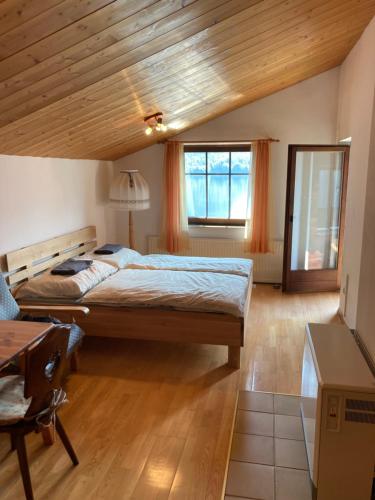 哈尔施塔特Privatzimmer am See的一间卧室设有一张大床和木制天花板