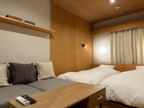 元箱根Lake Side Inn MIRAHAKONE的一间设有两张床和一张沙发的房间