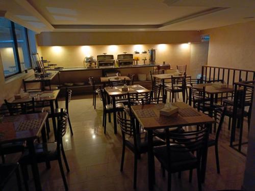 安曼Rayan Hotel Suites的一间带桌椅的餐厅和一间厨房