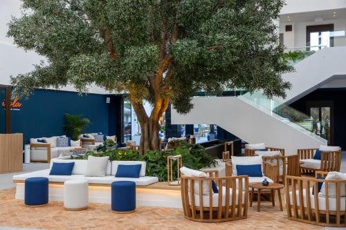 EsteponaMETT Hotel & Beach Resort Marbella Estepona的大堂设有椅子和树,楼梯