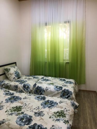 GarniHasy tun Guest House in GARNI 2的一间卧室设有两张床和绿帘