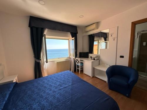 圣塔马利奈拉伊索拉酒店的一间卧室配有蓝色的床、一张书桌和一个窗户。
