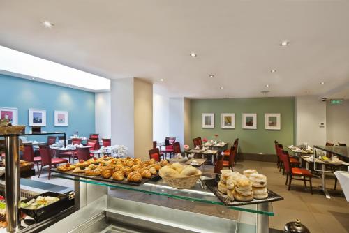 伦敦Gem Langham Court Hotel的餐厅内供应的自助餐包括面包和糕点