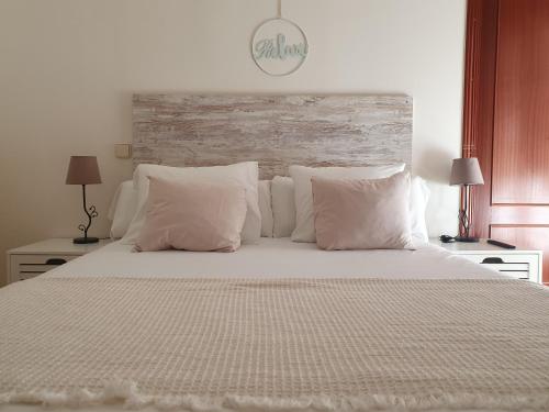 托莱多ToledoRooms Palacios的卧室配有一张带白色床单和枕头的大床。