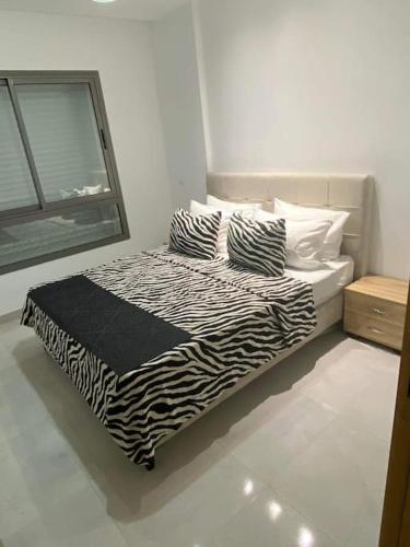 突尼斯Dar Kmar的一张带斑马印花床单和枕头的床