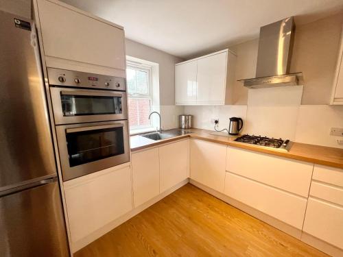 胡克Pex Residence: 5-Bedroom Home in Hook的厨房配有白色橱柜和不锈钢冰箱