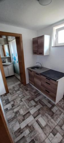 巴尼亚卢卡SOBE ROOMS GAVRILO的厨房配有木制橱柜和瓷砖地板。