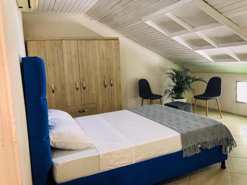 卡塔赫纳Casa Hotel Terraza del Cabrero的一间卧室配有一张带两把椅子和橱柜的床。