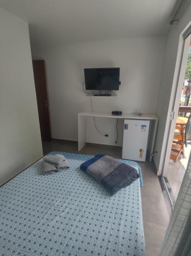 阿布拉奥Residencial 101 Ilha Grande的客房设有1张床、1台电视和1张桌子。