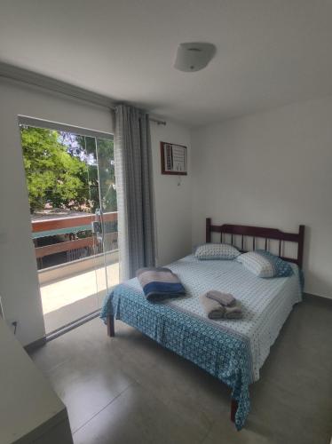 阿布拉奥Residencial 101 Ilha Grande的一间卧室设有一张床和一个大窗户