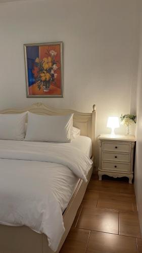 达叻府Rynn Hotel的一间卧室配有两张床和一个带灯的床头柜