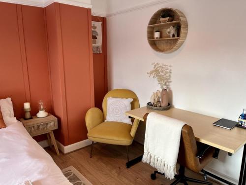 布莱克浦Elegant 2BD Family Retreat Blackpool Town的一间卧室配有书桌、两把椅子和一张床