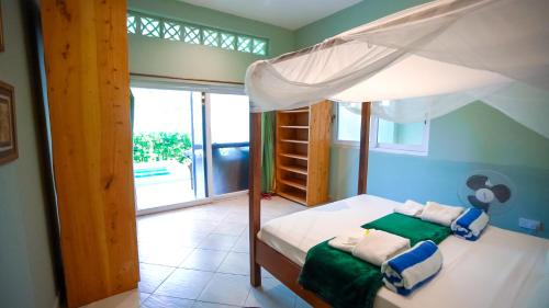迪亚尼海滩The Pool House & The Colobus House, Bella Seaview, Diani Beach, Kenya的一间卧室配有一张带天蓬的床