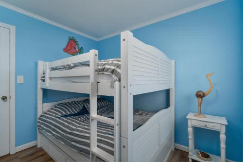 罗丹特7039 - A Wave From It All by Resort Realty的蓝色墙壁的客房内的一张白色双层床