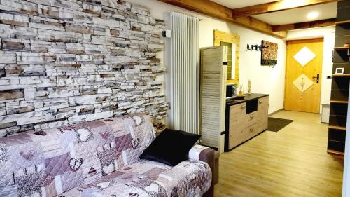 潘基阿Bilocale Nel Cuore Della Val Di Fiemme的客厅设有石墙和沙发。