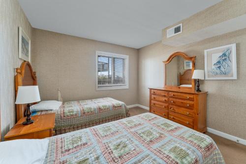 罗丹特7051 - Hatteras High 5A by Resort Realty的一间卧室配有两张床、一个梳妆台和镜子