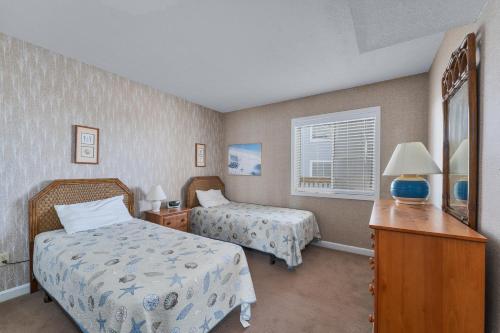 罗丹特7052 - Hatteras High 5B by Resort Realty的一间卧室设有两张床、一张桌子和一个窗口。