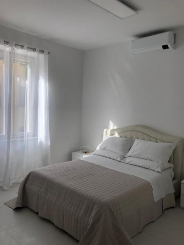 福利尼奥Casa Vacanze Il Divano Rosso的白色的卧室设有一张大床和一个窗户
