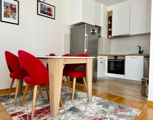 帕莱Apartman Pale Jahorina的厨房配有木桌和红色椅子