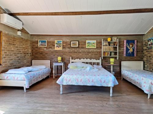 Costa DouradaCasas lindas no paraiso!的一间卧室设有两张床和砖墙