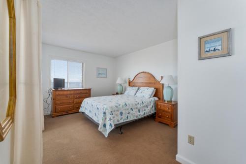 罗丹特7055 - Hatteras High 8C by Resort Realty的一间卧室配有床、两个梳妆台和窗户。