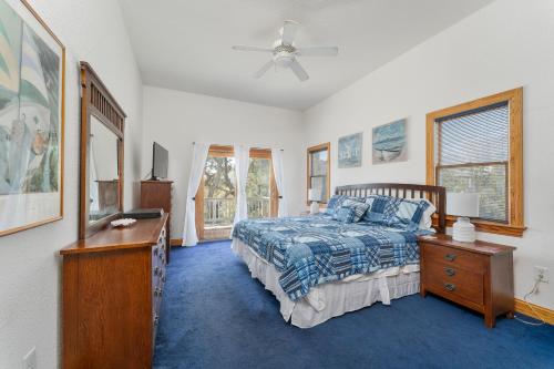 Waves7135 - Our Blue Haven by Resort Realty的一间卧室配有一张床、梳妆台和窗户。