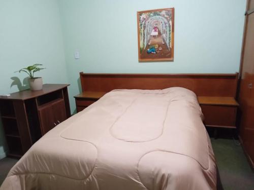 GerliL&J Departamento的卧室配有白色的床和木制床头板
