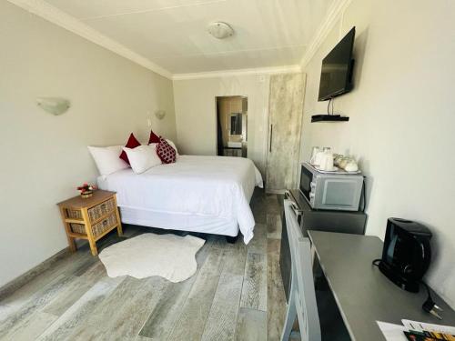 范德拜尔帕克Hillas Ridge Guesthouse的卧室配有白色的床和电视