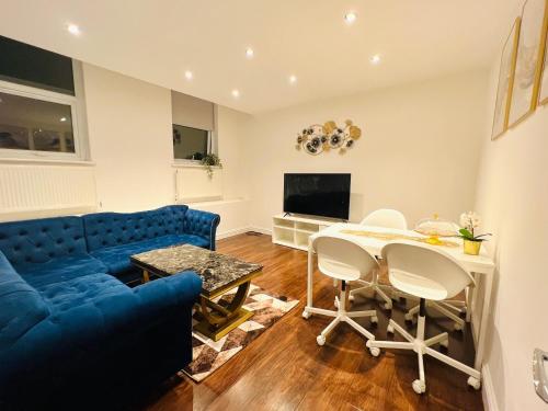 伦敦Luxury Morden 4 bedroom Flats which will make you unforgettable的客厅配有蓝色的沙发和桌子